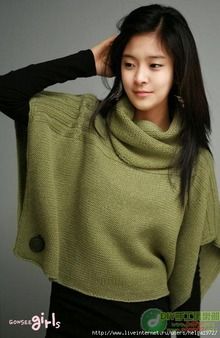 a woman with long hair wearing a green sweater and black pants is posing for the camera