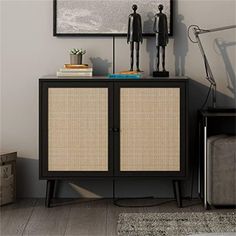 a black cabinet with two figures on top and a rug underneath it in a living room