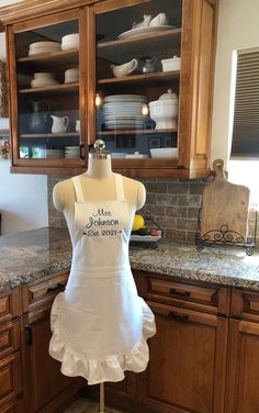 a mannequin is standing in front of a kitchen counter with dishes on it