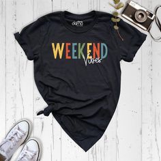 Embrace the carefree spirit of the weekend with our trendy Weekend Vibes Shirt. This shirt is designed to help you feel the positive energy and relaxation that comes with the weekend. Crafted with both style and comfort in mind, our Weekend Vibes Shirt features a playful design that radiates positive energy. It's the perfect choice for anyone looking to elevate their weekend wardrobe with a touch of fun and happiness. Made from high-quality materials, this shirt offers a soft and comfortable fit that is perfect for lounging or enjoying leisure activities. Whether you're spending time with friends, exploring new places, or simply unwinding at home, this shirt will keep you feeling comfortable and stylish. All sizes for Toddler T-Shirts are in stock. Please check the Toddler T-Shirt size cha Graphic Print T-shirt For Summer Weekends, Casual Weekend Tops With Text Print, Casual Text Print Tops For Weekend, Casual Graphic Print Tops For Weekend, Relaxed Text Print Top For Weekend, Casual Letter Print Tops For The Weekend, Relaxed Fit Text Print Top For Weekend, Spring Weekend Tops With Short Sleeves, Cotton Tops With Text Print For Weekend