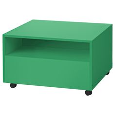 a green table sitting on top of a white floor next to a black object with wheels