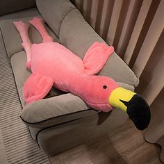 a pink stuffed animal laying on top of a couch