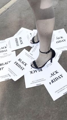 a woman's legs with black friday stickers on the ground in front of her