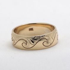 a wedding ring with an intricate design on the inside and outside, sitting on a white surface