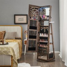 a large wooden jewelry rack in the corner of a bedroom