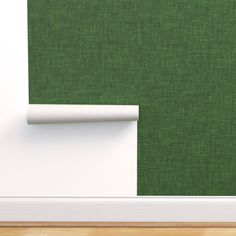 a green wall with white trim and a wooden floor