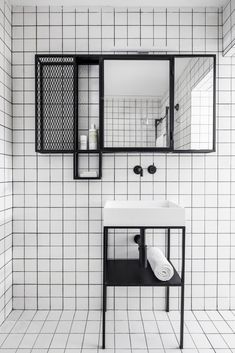 a black and white bathroom with tiled walls