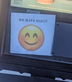 a sign that says we have egg on the front of a vending machine with a smiley face drawn on it