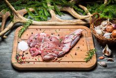 raw pork chops on a cutting board with spices and garlic