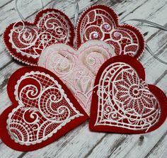 three red and white heart shaped appliques sitting on top of a wooden table