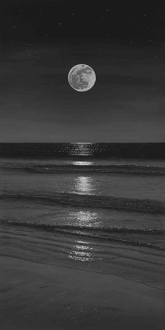 the moon is shining over the ocean on a dark night with stars in the sky