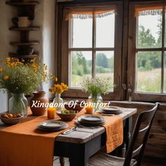 the table is set for two with plates and flowers in vases next to it