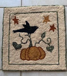 a close up of a rug with a bird on top of a pumpkin and stars