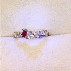 a diamond and ruby ring sits on a white cloth