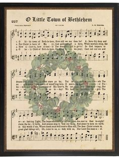 an old sheet with music notes on it and a wreath made out of green leaves