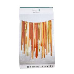 an orange string curtain hanging on a white brick wall in front of a white background