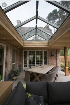 an enclosed patio with table and chairs under a glass roof over the dining room area