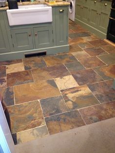 a kitchen with green cabinets and tile flooring