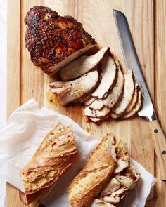 sliced meat and slices of bread on a cutting board with a knife next to it