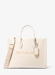 Crafted from pebbled leather in a structured silhouette, the Mirella tote features our iconic brand lettering and a polished logo charm for an ultra-luxe finish. With sleek top-handles and a woven crossbody strap, this bag will be your new daytime go-to. Wear it with denim and a classic white shirt. Michael Kors Purse Aesthetic, Classic Everyday Bags With Metal Logo, Leather Bags With Metal Logo For Shopping, Leather Shopping Bags With Metal Logo, Leather Bags With Metal Logo, Elegant Logo Bags For On-the-go, Classic Top Handle Bag With Metal Logo, Classic Bags With Logo For On-the-go, Leather Double Handle Bag With Metal Logo