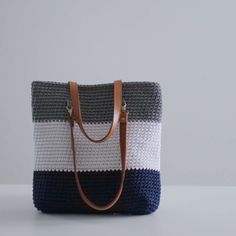 the simple crochet bag made of macrame yarn and leather handles is shown