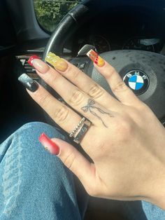 a woman's hand with colorful nail polish and ring tattoos on her left thumb