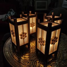 four lit up lanterns sitting on top of a table