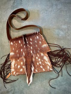 "Definite showstopper Crossbody Axis deer hide handbag, with slight triangle shape. The flap on front has the tail, which makes it unique to most Axis deer hide purses. More than one purse can be made from a hide, BUT there's only one tail per hide, making this purse a rare find! Purse has an inner divider and inner pocket for organization. Leather fringe embellishes the two sides of purse. All my purses are handmade and one of a kind.  The approximant measurements on this purse are 11\" across Axis Deer Hide, Axis Deer, Deer Hide, Deer Pattern, Leather Fringe, Triangle Shape, Taxidermy, Cross Body Handbags, Purses And Handbags