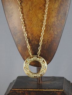 "FABULOUS Donut Vintage Pendant. It is gold toned and from the 1960s. Never before worn. In excellent vintage condition. Beautiful filigree work within the pendant! This pendant has two pieces, as you can see in the last photo! For those of you who are handy, you could actually turn them into hoop earrings! (Just a vintage repurposed idea Hangs from a fabulous 22\" vintage chain. The pendant measures 1 7/8\" in diameter. Perfect addition to your vintage collection!" Vintage Metal Medallion Necklace With Large Pendant, Vintage Gold-tone Medallion Necklace For Gift, Vintage Brass Jewelry With Gold Chain, Retro Gold Round Pendant Jewelry, Gold Retro Round Pendant Necklace, Gold Retro Round Pendant Jewelry, Retro Gold Medallion Jewelry, Vintage Gold-tone Pendant Jewelry, Vintage Gold-tone Round Pendant Jewelry