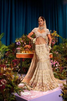 "Unveil Eternal Elegance - Our All Ivory Bridal Lehenga Set is a vision of grace and allure. Soft pink crystals and shimmering gold metals create a celestial beauty. Our signature ivory blouse with tassels adds a modern touch, while a soft ivory tulle head veil completes the enchantment. Step into the spotlight with this captivating ensemble, making your special day truly unforgettable." Colour: Ivory Fabric: Tulle / Fluid / Organza Technique: Hand Embroidery, Patchwork No of set: 3 Delivery Tim Traditional Hand Embellished Sharara For Ceremony, Elegant Fitted Lehenga With Intricate Design, Intricate Design Fitted Wedding Lehenga, Fitted Wedding Lehenga With Intricate Design, Intricate Design Fitted Lehenga For Weddings, Wedding Lehenga With Intricate Design, Hand Embellished Traditional Drape Set For Ceremony, Hand Embellished Sets For Ceremony With Traditional Drape, Elegant Wedding Sharara With Gold Embroidery