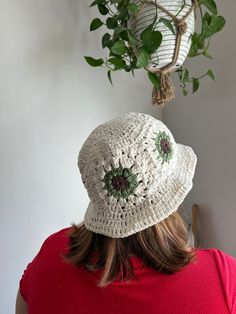 a woman wearing a white crocheted hat and red shirt