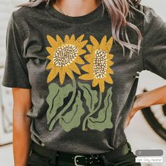 Description: Our "Boho Sunflower" design on Bella Canvas cotton Unisex T-shirt.  The American graphic tee shirt is an icon of individuality around the world. Who doesn't love a good t-shirt day? It means you get to feel comfortable wherever you're headed, while also showing off your style and personality!  Feel confident you are purchasing a quality product that is eco-friendly and produced in America. Our DTG printing is eco-friendly utilizing water based inks! Our shirt manufacturer, Bella+Can Patterned Floral Print Cotton T-shirt, Green Bohemian T-shirt For Summer, Casual Patterned Spring T-shirt, Vintage Short Sleeve T-shirt With Plant Print, Bohemian Yellow Summer Shirt, Casual Patterned Top With Plant Print, Summer Casual T-shirt With Sunflower Print, Spring Patterned Short Sleeve T-shirt, Bohemian Short Sleeve T-shirt For Fall