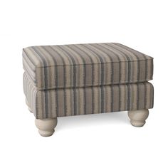 a striped ottoman sitting on top of a white floor