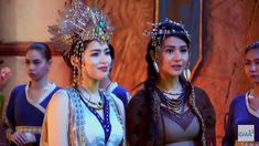 three women in costume standing next to each other and one is wearing a headdress