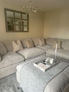 a living room with a couch, coffee table and mirror