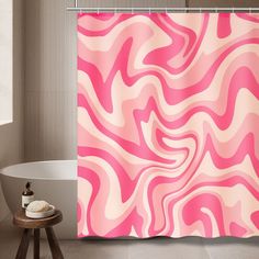 a pink and white shower curtain in a bathroom with a bathtub next to it