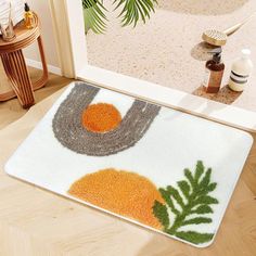 a door mat with an orange and grey design on the floor next to a mirror