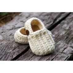 a pair of crocheted baby shoes sitting on top of a wooden table