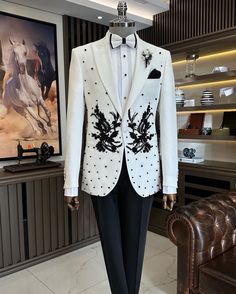 Make an edgy statement with White EMBROIDERED suit designed thoughtfully for the modern  man. A fusion staple fit for every occasion, adds the right amount of cultural twist to the western silhouette. Color: white Garment Type: Indo Western Neck: tuxedo Fabric: Micro Velvet Embroidery: Zari work with sequin embroidery The Product Price is inclusive of: 1 Indo-Western and 1 Trouser Style Bottom and 1 shirt Product color may slightly vary due to photographic lighting sources or your screen setting Designer White Party Suits, Designer Embroidered Blazer For Groom, Fitted Black Sherwani For Ceremony, Black Tuxedo Blazer For Ceremonies, Designer Blazer For Groom, Embroidered Tuxedo Blazer For Groom, Luxury Groom Suits For Winter, Designer Long Sleeve Wedding Tuxedo, Winter Wedding Tuxedo Suit