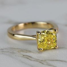 a yellow diamond ring sitting on top of a table