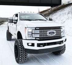 a white truck driving down a snow covered road