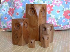 three wooden blocks sitting on top of a table next to a flowery bag and pillow