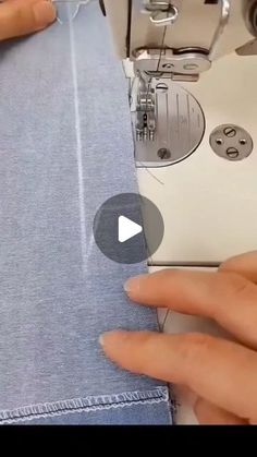 someone is using a sewing machine to sew on some blue jean pants with buttons