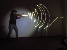 a man standing in front of a wall with light painting on it's walls