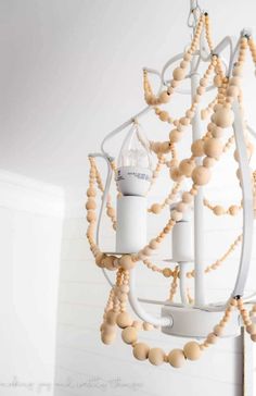 a wooden beaded chandelier hanging from the ceiling in a room with white walls