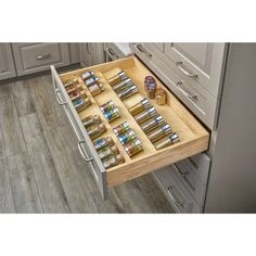 an open drawer in the middle of a kitchen with spices and condiments on it