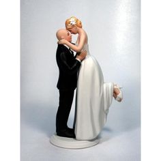 a bride and groom figurine holding each other