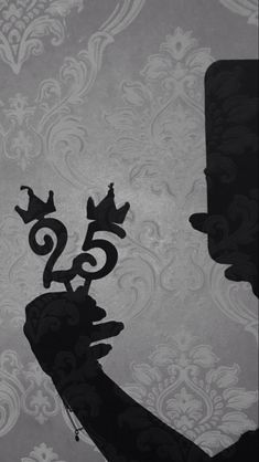 the silhouette of a man with a crown on his head, in front of a wallpapered background