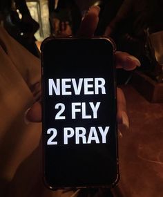 someone holding up their phone with the text never 2 fly 2 pray