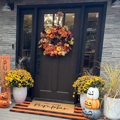 front door decorated for halloween with pumpkins and mumlocks